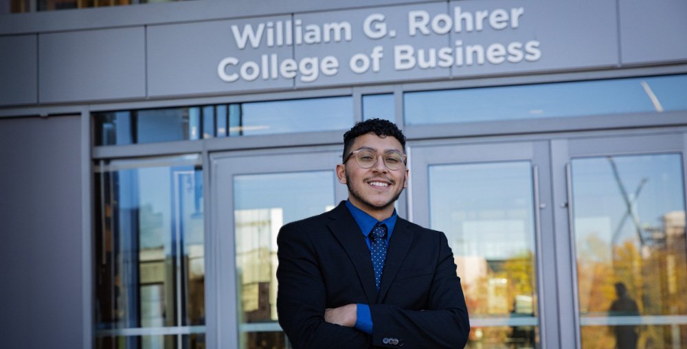 A Rohrer College of Business student poses for a photo outside of Business Hall on Rowan University's main campus.