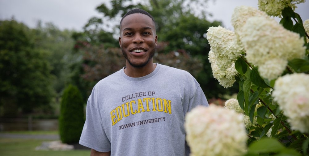 A Rowan University College of Education student smiles for a photo outside.