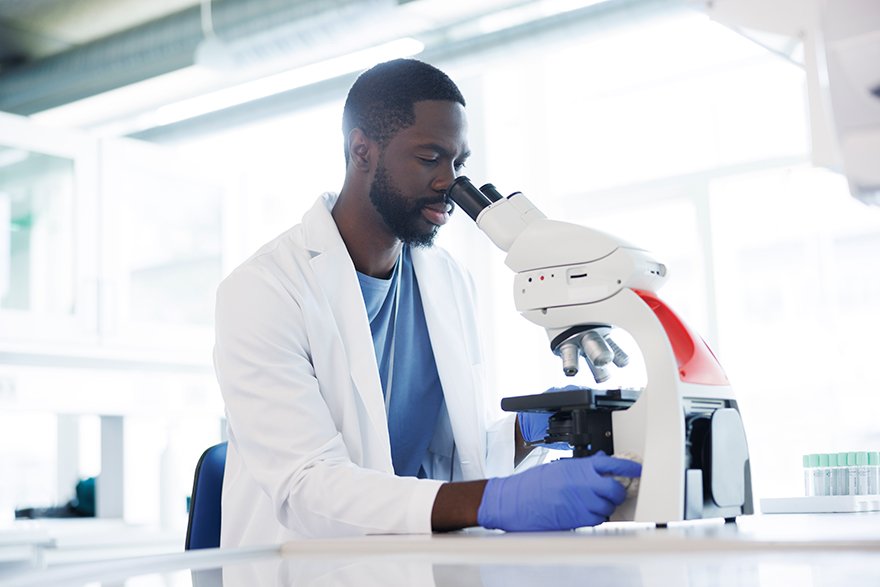 Male scientist looking into microscope