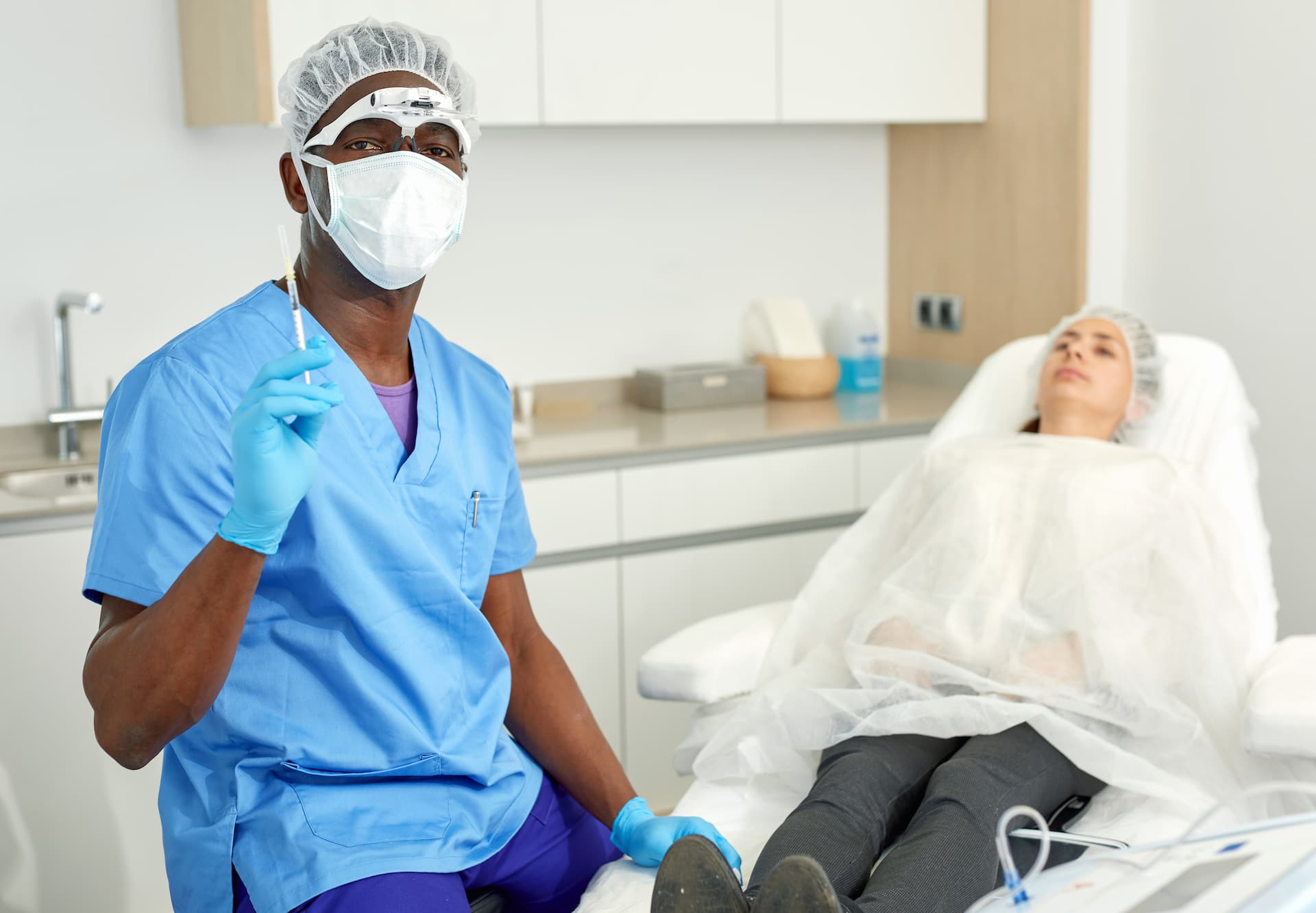 doctor in scrubs preparing to do injection procedure