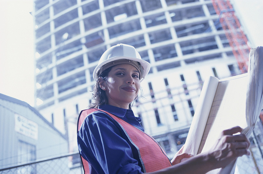 a professional reviewing blueprints at a construction site