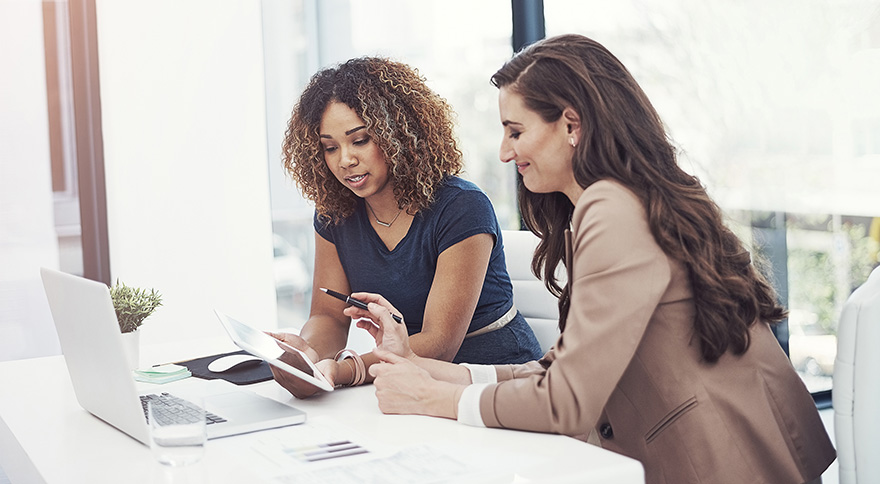 two women working together over a computer
