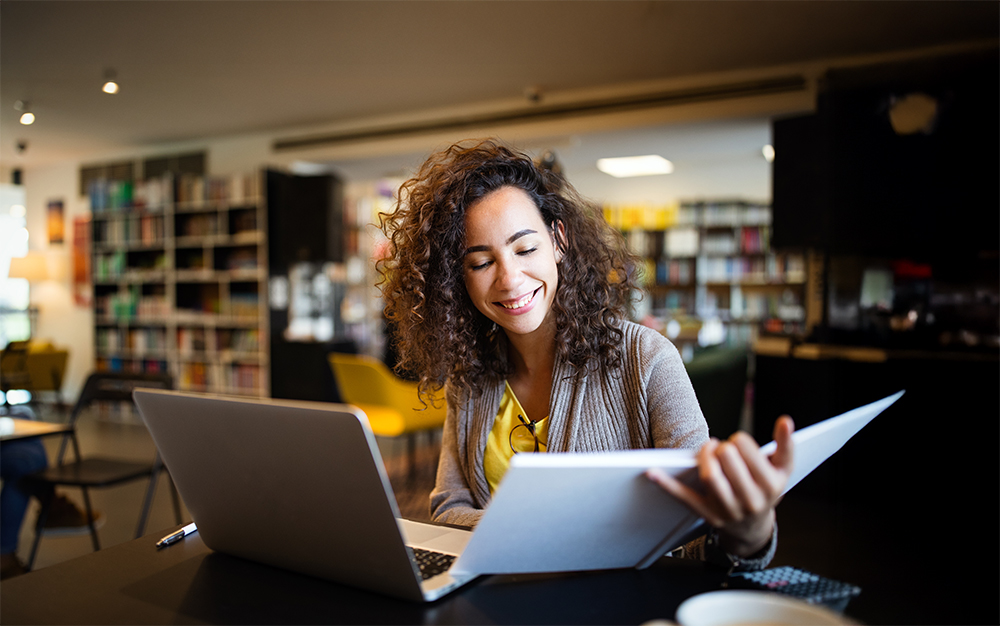 A student reads a book in the stacks of the Campbell Library.