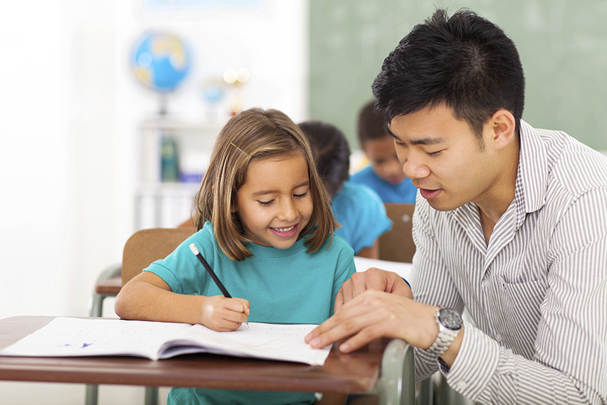 a teacher works with a student in the classroom