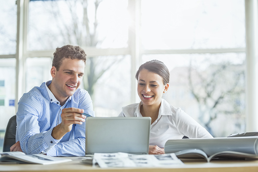 two professionals working at a laptop