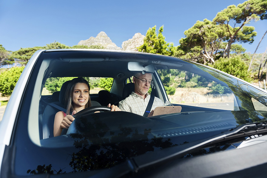 a person learning to drive in a driver's ed car