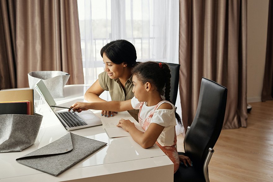 an adult and child working together at a desk
