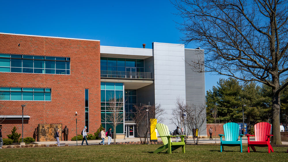 Exterior shot of James Hall with students walking in front.
