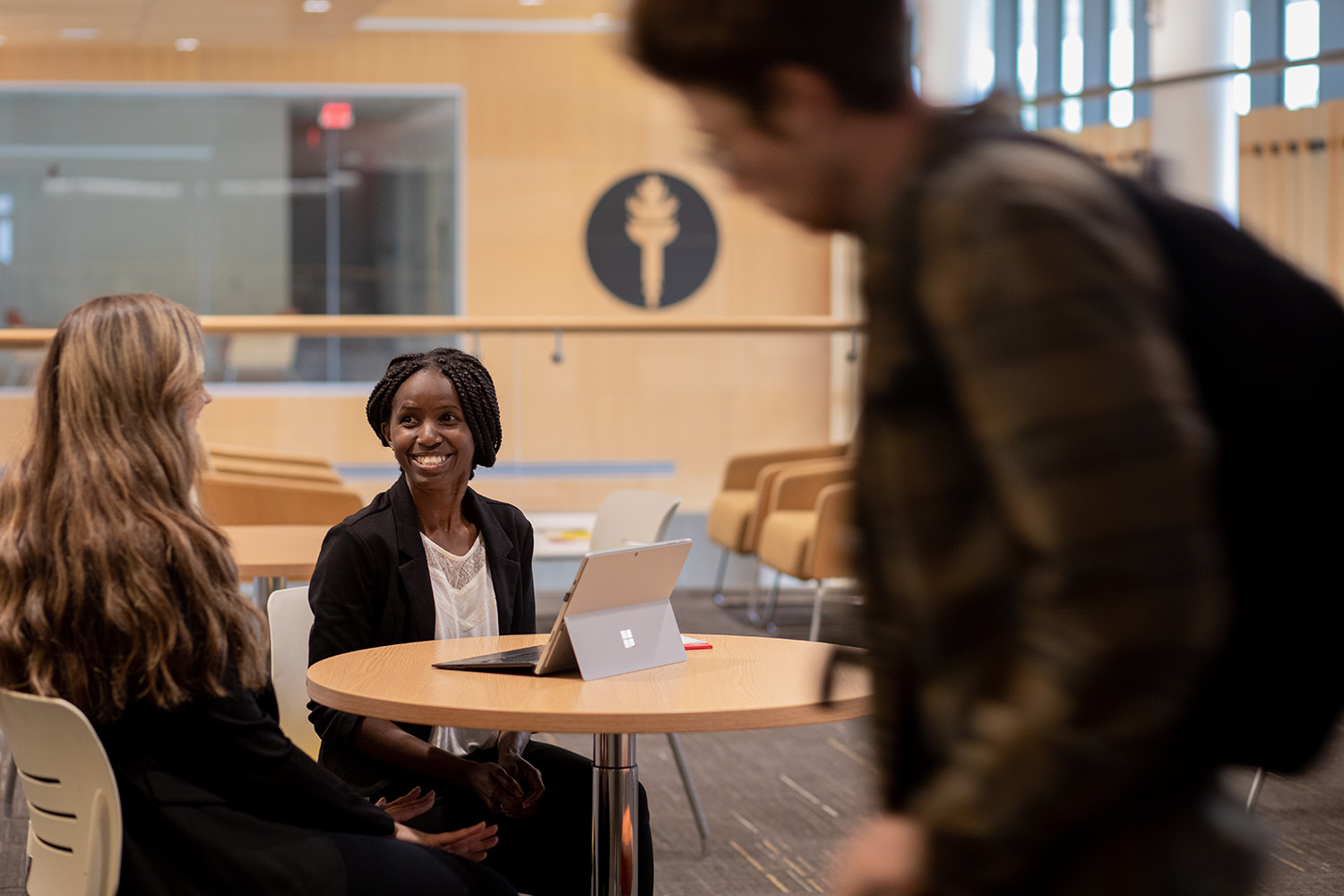 Two Rowan University students talking in an academic building on campus.
