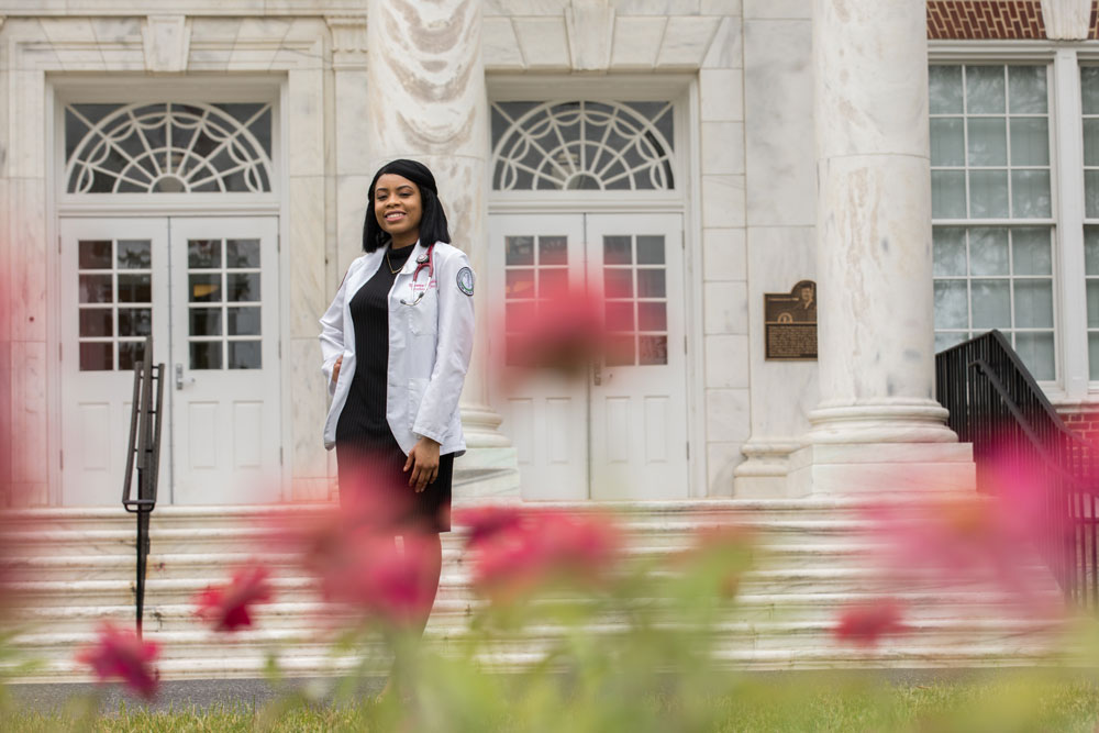 medical student stands outside of Bunce Hall