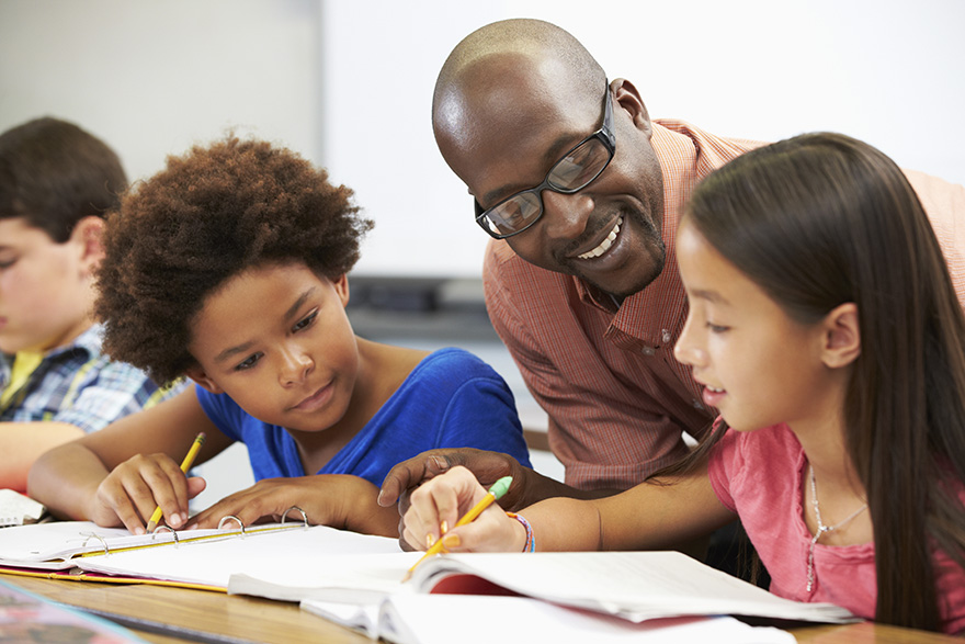 a teacher working with students and books