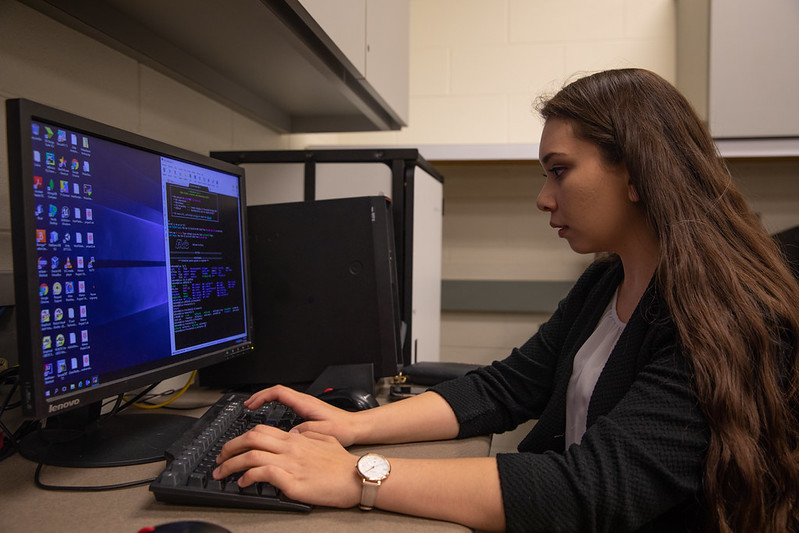 a student works at her computer in a lab