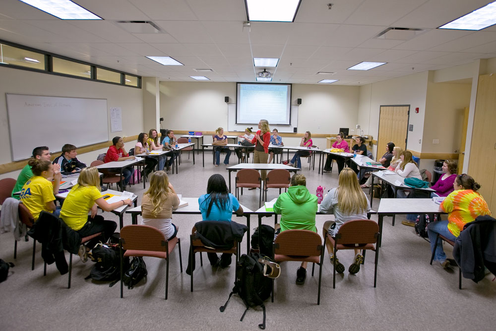 a teacher works with students in a science classroom