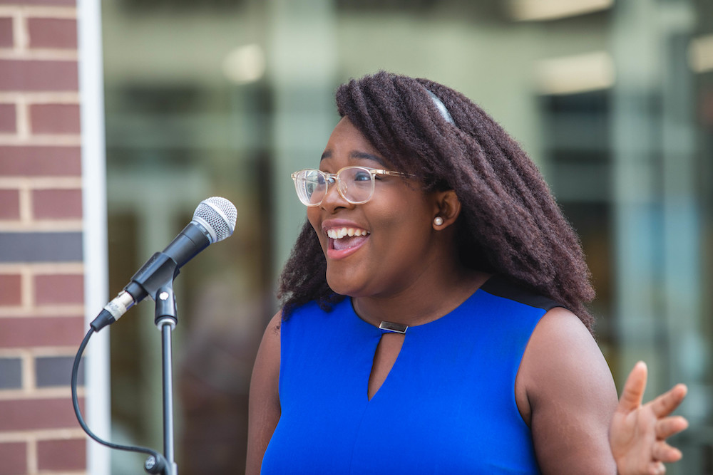 Student speaks into a microphone at an event.